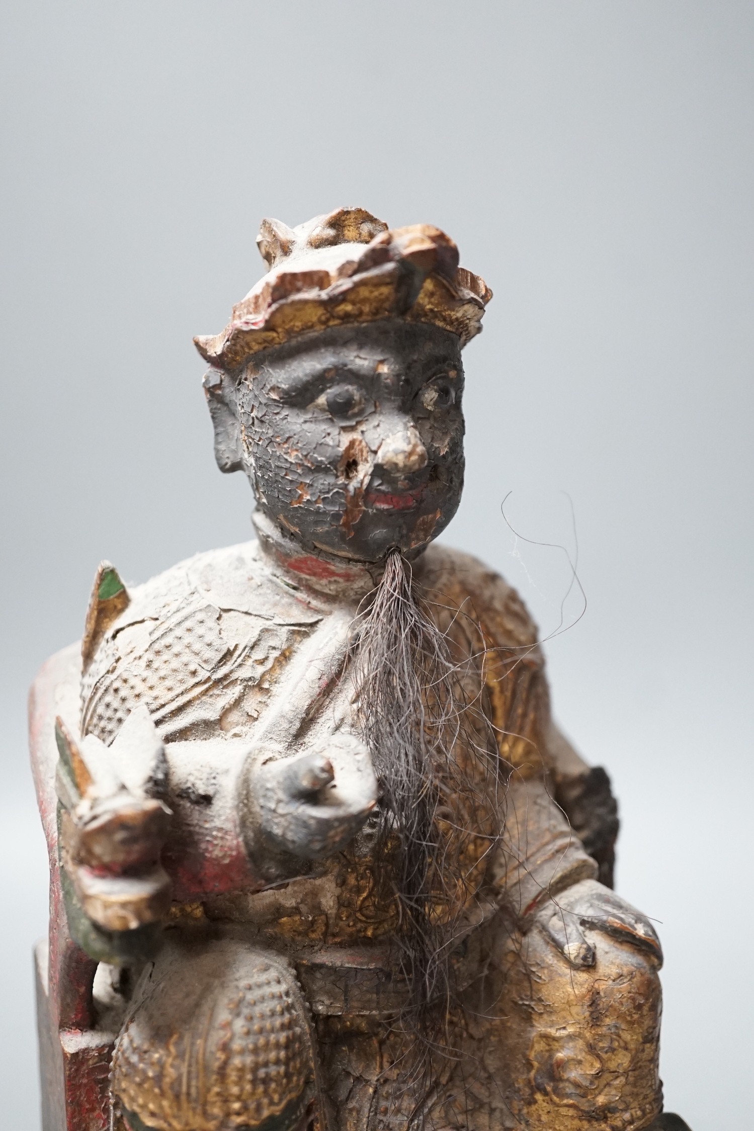 A 19th century Chinese painted wood figure with ink inscription verso, 24.5cms high